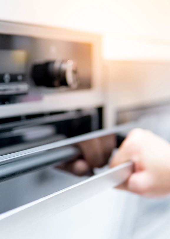 Person opening an oven door made with polymers that replace metal.