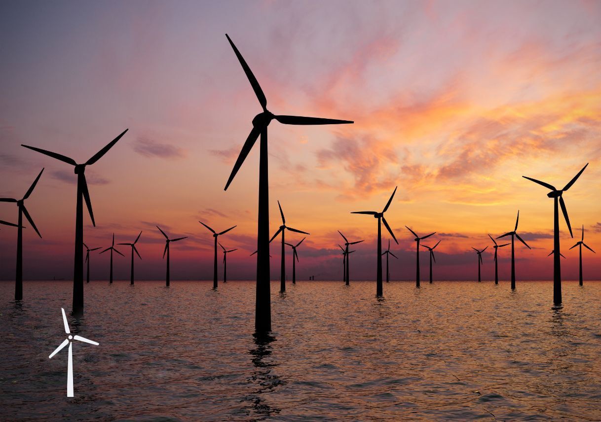 Wind turbines surrounded by water at sunset