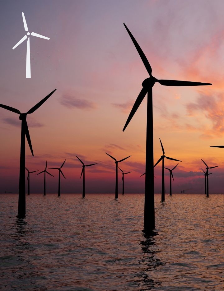 Wind turbines surrounded by water at sunset