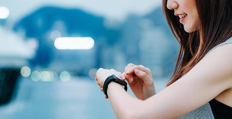 妇女与智能手表互动的智能手表作为从杜邦的电技术解决方案的例子