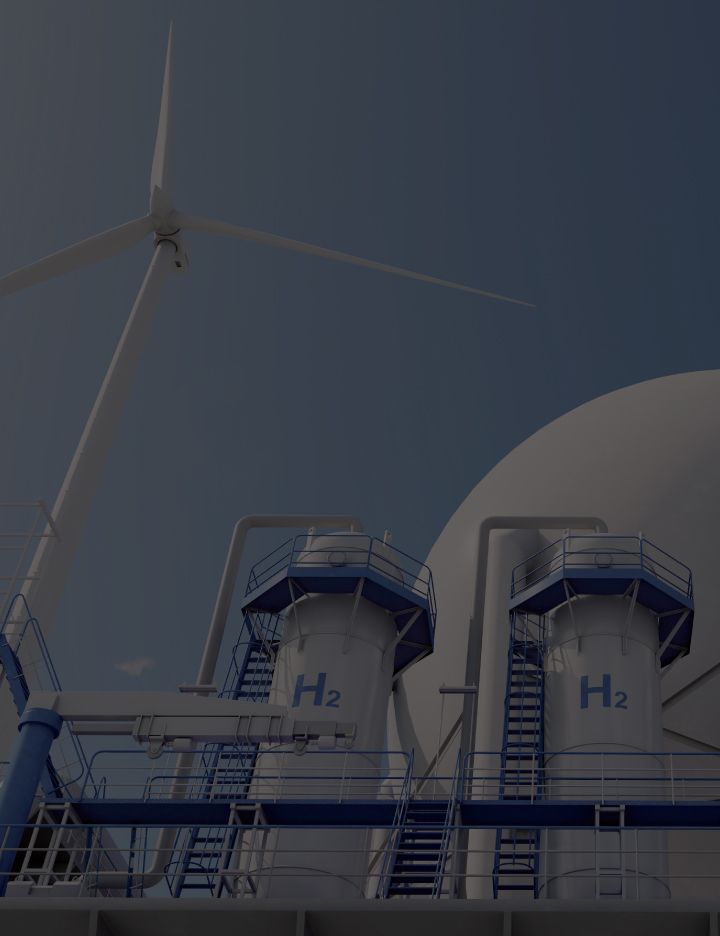 A couple of metal tanks labeled H2 sitting in front of a large round reservoir and a wind turbine.