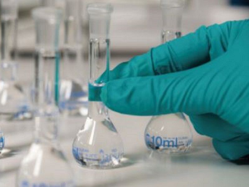 Person performing system optimization services with beakers of water