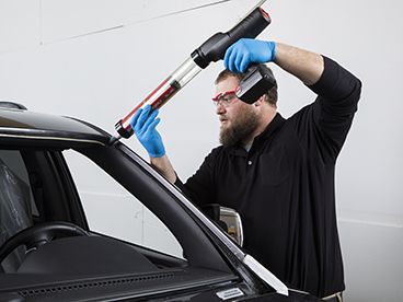 Technician applying BETASEAL to windshield area